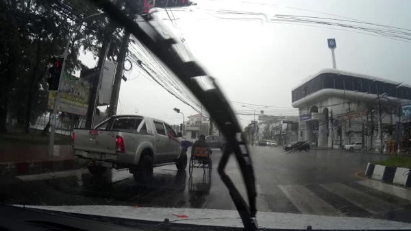 Barmhartige automobilist geeft paraplu aan zeiknatte gehandicapte bakfiets