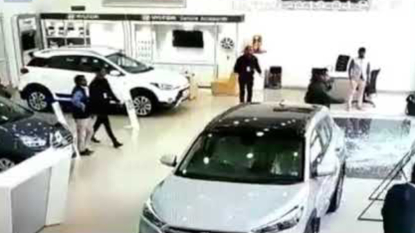 Beginnend bestuurder jakkert gloednieuwe auto dwars door een showroom
