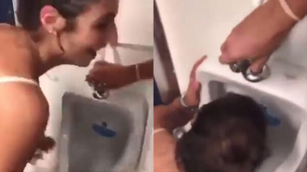 Dronken Debbie heeft ontzettende nadorst en drinkt water uit een urinoir