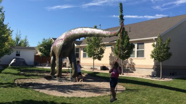 Knutselheld bouwt enorm dinosaurus-speeltoestel voor zijn koters