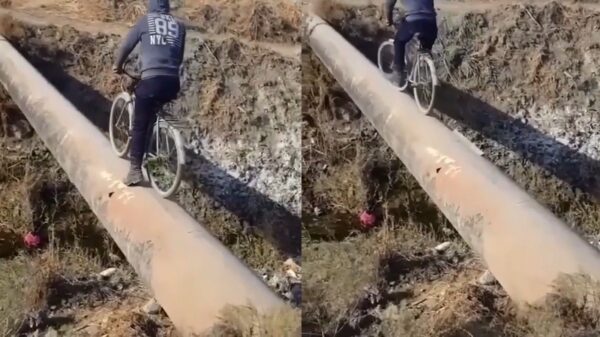 Onnozele gaat uitdaging aan om over een stalen buis te fietsen