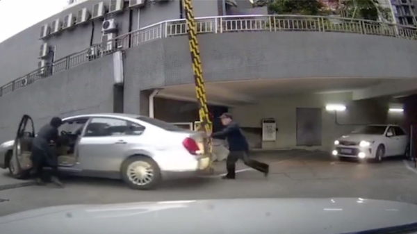 Aziatische vrouw zet haar auto in de achteruit en rijdt zichzelf ondersteboven