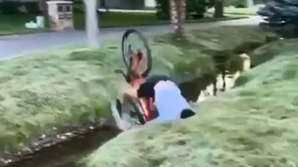 Stuntpiloot probeert op zijn fiets over een sloot te jumpen