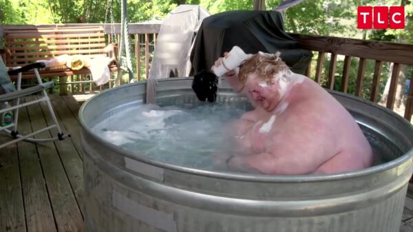 Naakte dikke gamer past niet in bad dus wast hij zich buiten