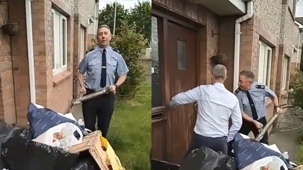 Ierse politieagent heeft de nodige moeite met het openbreken van een deur