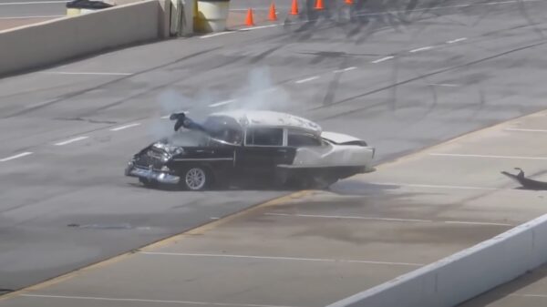 Coureur slaat over de kop en bungelt uit zijn voorruit na dragrace tussen oldtimers