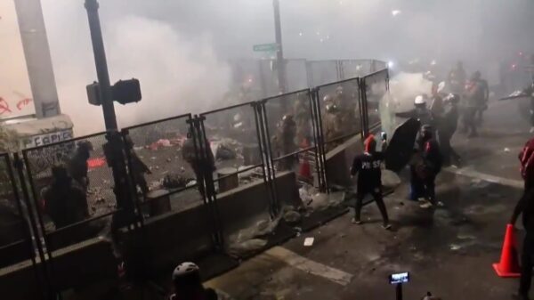 Lacrosse-baas gebruikt zijn stick om een traangasgranaat terug naar de politie te gooien