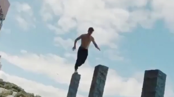 Parkourprofessional heeft geen enkele moeite met een setje hoge palen