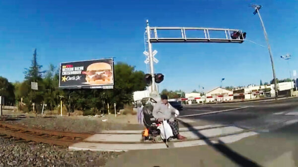 Man in rolstoel op het laatste moment voor aanstormde trein weggehaald