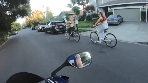 Motorrijder zorgt ervoor dat jongedames niet goed opletten tijdens het fietsen