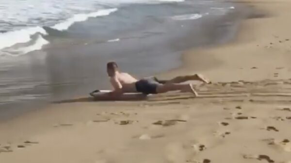 Een poging tot zandsurfen eindigt met een flinke klapper in zee