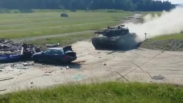 Tank vlamt op volle snelheid dwars door een auto heen